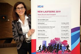 Christina Achtnich, Leiterin Kommunikation bei der NEW, präsentiert das Plakat zu 9. NEW-Laufserie. 